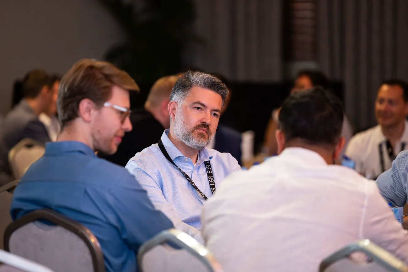 A member in conversation with peers at an in-person industry event