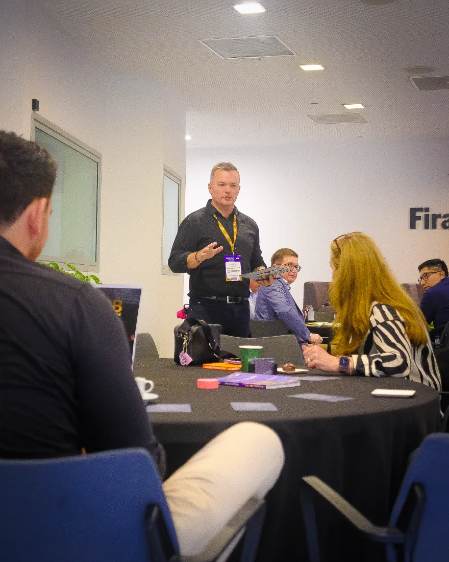 Leo Judkins presenting to a small seated group during a live mastermind session